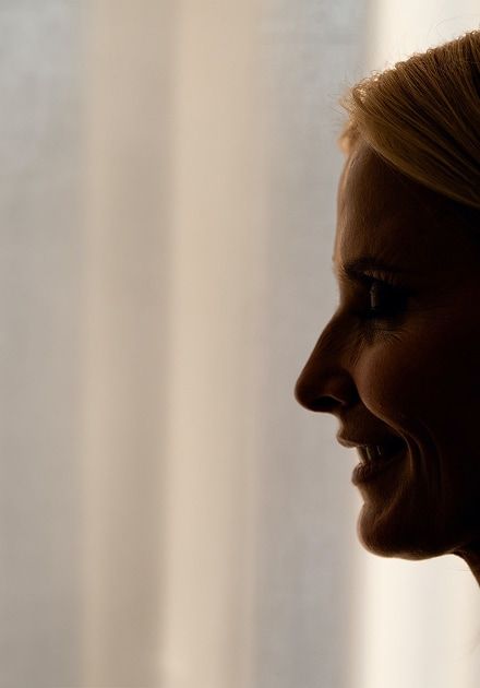 Silhouetted profile of a smiling woman with blonde hair.